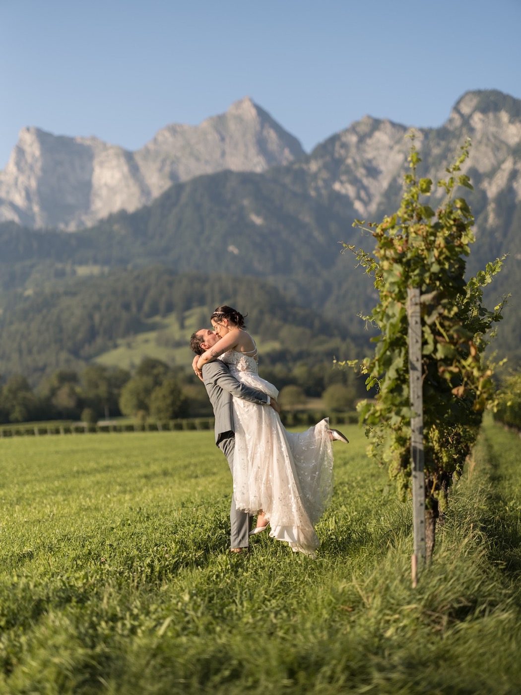 Bräutigam hebt Braut hoch, verspielte Pose fürs Hochzeitsshooting, Hochzeitsfotograf Graubünden